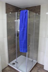 y baño con ducha y toalla azul. en Ferienhaus „Strandhafer“ en Zingst