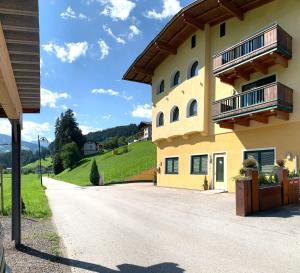 a large yellow building with balconies on a road at Appartements Samerhof - TOP 1 in Kaltenbach