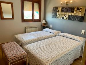 a room with two beds and a mirror at Hostal Delgado in Benabarre