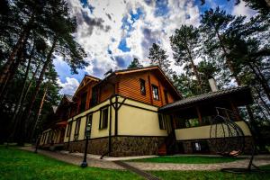 a large wooden house in the middle of a forest at Явір Резорт in Starychi