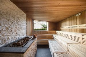 an empty sauna with wooden benches and a window at Boutique Hotel Zum Rosenbaum in Nalles