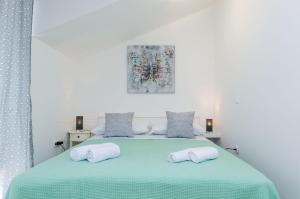 a bedroom with a green bed with two pillows at Holiday Home Barbara in Ston