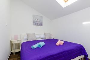 a bedroom with a purple bed with two pillows on it at Holiday Home Barbara in Ston