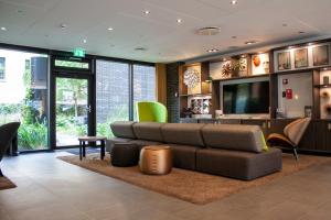 a living room filled with furniture and a tv at Wakeup Copenhagen - Borgergade in Copenhagen