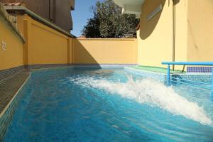 a pool with a water slide in a building at Семеен хотел Бостън in Ravda