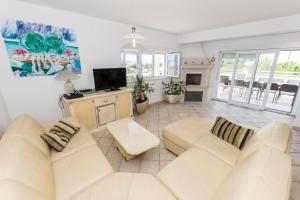 a living room with two white couches and a tv at Villa Ozzi with 9 bedrooms & private Pool in Makarska