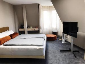 a bedroom with two beds and a flat screen tv at Hotel Krumbach in Krumbach