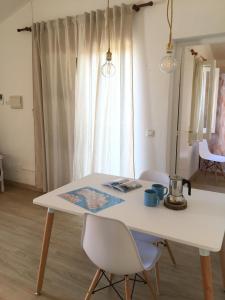 una mesa y sillas blancas en una habitación con ventana en Apartamentos Surest en Cala en Blanes