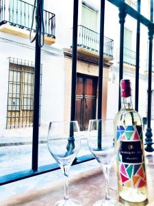 アンテケラにあるCENTRO ANTEQUERA Apartamento Las Recoletasのワイン1本とグラス2杯