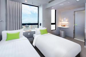 2 camas en una habitación con ventana grande en Hotel Ease Mong Kok en Hong Kong