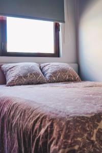 波瓦－迪瓦爾津的住宿－Apartamento Torreão，卧室内的一张床铺,设有大窗户