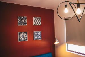 een kamer met een rode muur met foto's erop bij Apartamento Torreão in Póvoa de Varzim