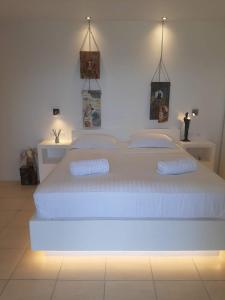 MelissakiにあるPelaginiの白いベッドルーム(照明付きの大きな白いベッド付)