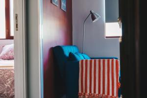 a room with a blue chair and a lamp and a bed at Apartamento Torreão in Póvoa de Varzim