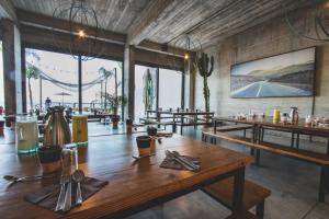 a restaurant with wooden tables and chairs and tablesearcher at Amouage by Surf Maroc in Taghazout