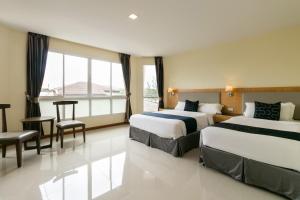 pokój hotelowy z 2 łóżkami i stołem w obiekcie Golden Beach Boutique Resort w mieście Prachuap Khiri Khan