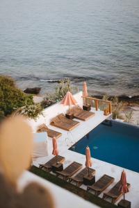 a group of chairs and umbrellas next to a pool at Amouage by Surf Maroc in Taghazout