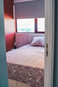 um quarto com uma cama num quarto com uma janela em Apartamento Torreão na Póvoa do Varzim