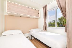 Łóżko lub łóżka w pokoju w obiekcie Camping Stella Maris Mobile Homes