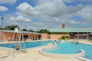 - une grande piscine avec une échelle devant un bâtiment dans l'établissement Spacious Quentoinise Town House, à Saint-Quentin
