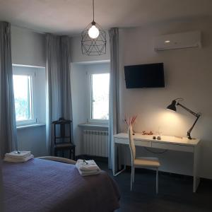 een slaapkamer met een bed, een bureau en een lamp bij Casa Chiocconi in La Spezia