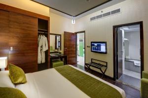 a bedroom with a bed and a bathroom with a television at Sunday Marina View Hotel Apartments in Dubai +51 photos