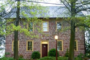 uma casa de tijolos com uma porta vermelha e árvores em Brownstone Colonial Inn em Reinholds