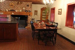 comedor con mesa, sillas y chimenea en Brownstone Colonial Inn, en Reinholds