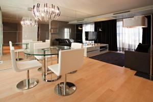 a dining room with a glass table and white chairs at Serviced Apartments Boavista Palace in Porto