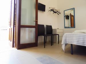 サン・ヴィート・ロ・カーポにあるAppartamenti Leone1のベッド、テーブル、鏡が備わる客室です。