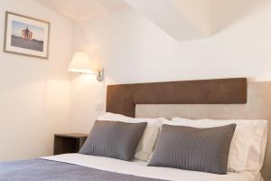 a bedroom with a bed with a wooden headboard at Liberty Palace in Milazzo