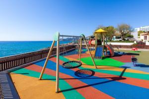 einen Spielplatz mit Rutsche und Schaukel in der Unterkunft Apartamento Maritim in Cala Ratjada