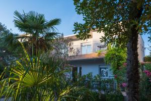 ein von Bäumen und Pflanzen umgebenes Gebäude in der Unterkunft Apartments Sky in Vodice