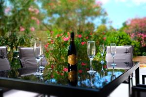 una botella de vino sentada en una mesa con copas de vino en Apartments Sky, en Vodice