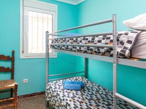 a bedroom with two bunk beds and a blue wall at Apartment Villa Cordoba-1 by Interhome in Port de la Selva