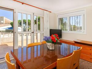 a dining room with a table with a vase of flowers at Apartment Villa Cordoba-1 by Interhome in Port de la Selva