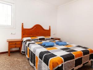 1 dormitorio con 1 cama con manta a cuadros en Apartment Villa Cordoba-1 by Interhome, en Port de la Selva