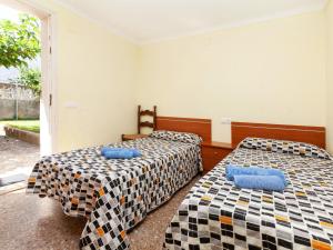 two beds in a room with checkered sheets at Apartment Villa Cordoba-1 by Interhome in Port de la Selva