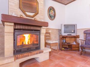 sala de estar con chimenea y TV en Holiday Home Rural Cacin by Interhome, en Cacin