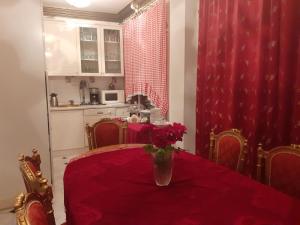 a kitchen with a table with a vase of flowers on it at Apartmani Vivaldi Niš in Niš
