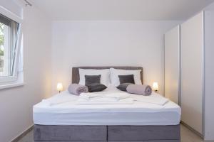 ein Schlafzimmer mit einem großen weißen Bett mit zwei Kissen in der Unterkunft Apartments Sky in Vodice + 104 Fotos