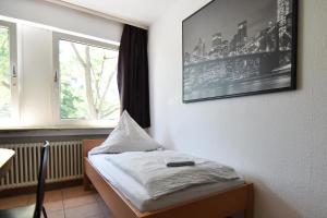 Zimmer mit einem Bett und einem Fenster in der Unterkunft Köln Höhenberg in Köln