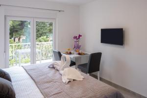ein Schlafzimmer mit einem Bett und einem Tisch und einem Fernseher in der Unterkunft Apartments Sky in Vodice