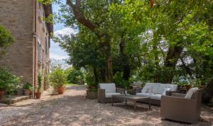 un patio con sofás, una mesa y árboles en Relais Casamassima, en Ponte Felcino
