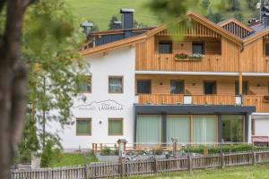 a large white building with a wooden roof at App. Erta - Ciasa Lavarella in San Vigilio Di Marebbe