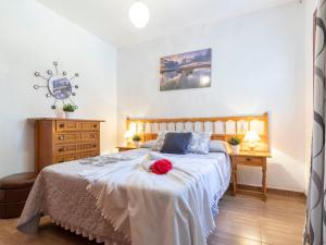 a bedroom with a bed with a red rose on it at Holiday Home Coquetó by Interhome in Riumar