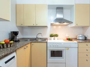 una cocina con armarios blancos y fregadero en Holiday Home Coqueto by Interhome, en Riumar