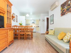 a living room with a couch and a dining room at Holiday Home Coquetó by Interhome in Riumar