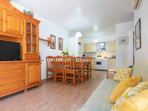 a living room with a dining room table and a kitchen at Holiday Home Coquetó by Interhome in Riumar