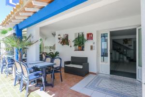a patio with a table and chairs and a couch at Hotel Les Palmiers En Camargue in Saintes-Maries-de-la-Mer